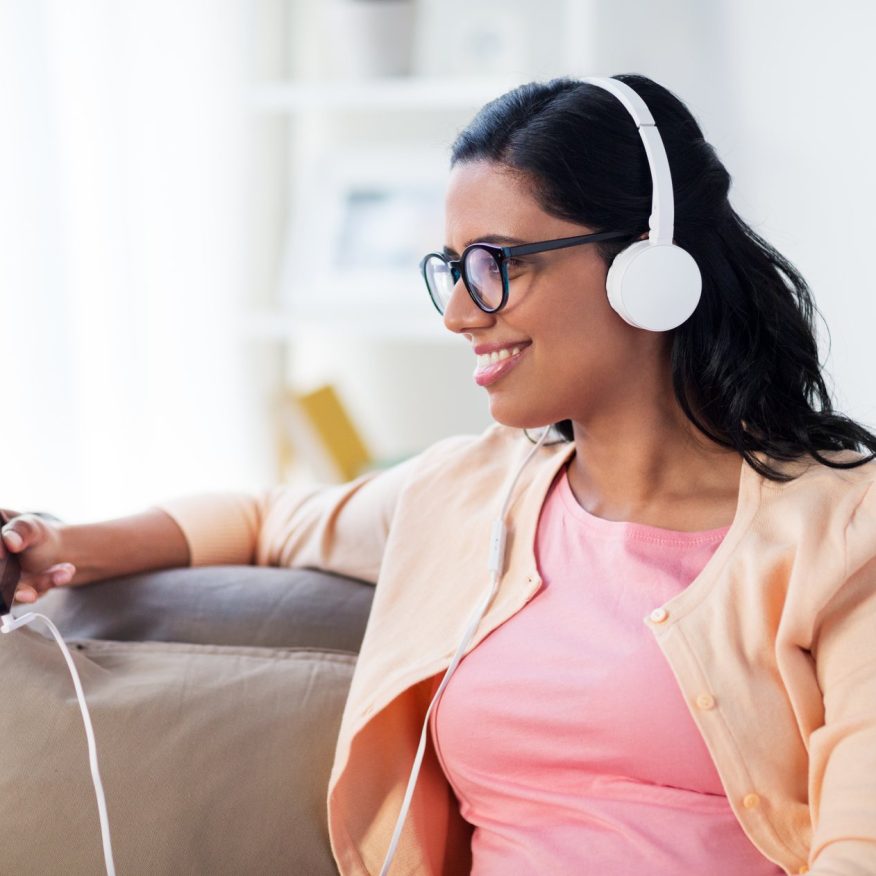 happy-woman-with-tablet-pc-and-headphones-at-home-P32QZJA-1.jpg